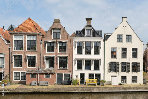 View on a row of canal houses on Het Grootdiep in Dokkum Friesland The Netherlands on a sunny day in spring. Dokkum is one of the Frisian eleven cities.   #597475211