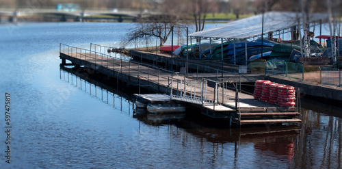 Boat station on the river in early spring. An empty pier on the background of water.