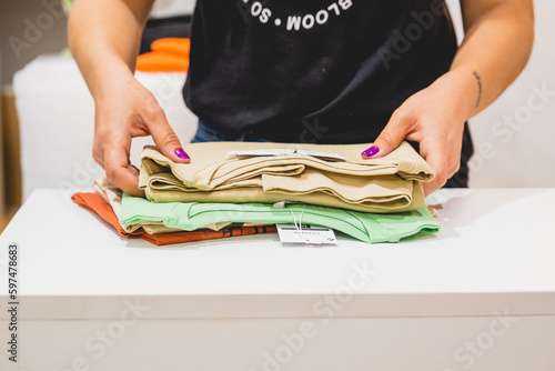 manos chicas ordenando camisetas para enviar paquete online 