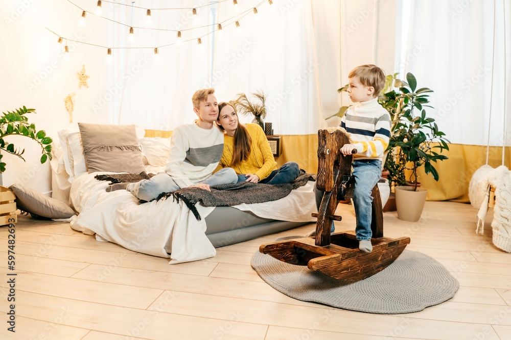 Happy family in bedroom, yellow gray colors.