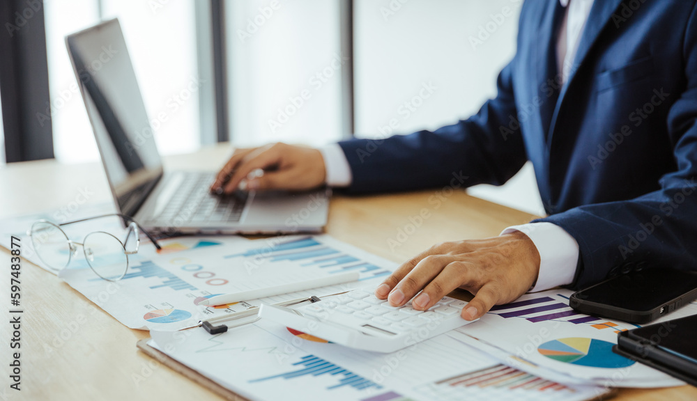 Close up of business analysis, investment and finance concept. Businessman, accountant calculating business report. market information Financial graph while working on laptop computer with spreadsheet Close up of business analysis, investment and finance concept. Businessman, accountant calculating business report. market information Financial graph while working on laptop computer with spreadsheet