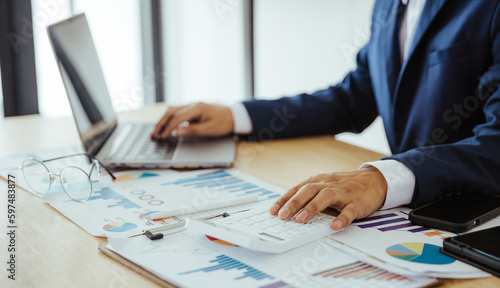 Close up of business analysis, investment and finance concept. Businessman, accountant calculating business report. market information Financial graph while working on laptop computer with spreadsheet