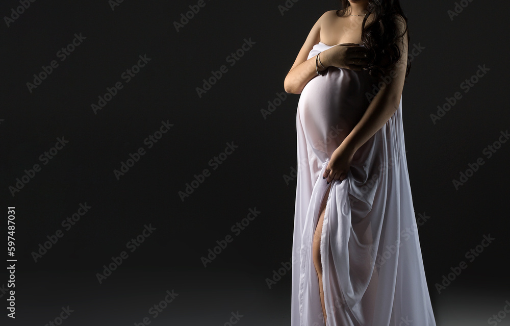 Pregnant woman in white dress. Pregnancy woman in a white dress on a grey background. Copy space. Pregnant silhouette. Pregnant woman in white dress. Pregnancy woman in a white dress on a grey background. Copy space. Pregnant silhouette.