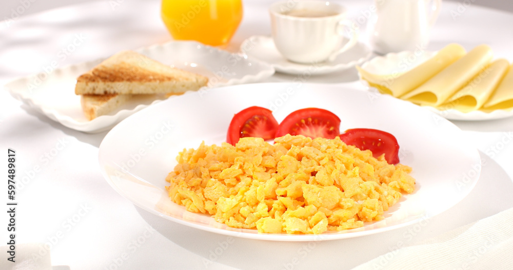 scrambled eggs with bacon and tomato. breakfast on a white plate. food on a sunny morning. fried eggs close-up. scrambled eggs with bacon and tomato. breakfast on a white plate. food on a sunny morning. fried eggs close-up.