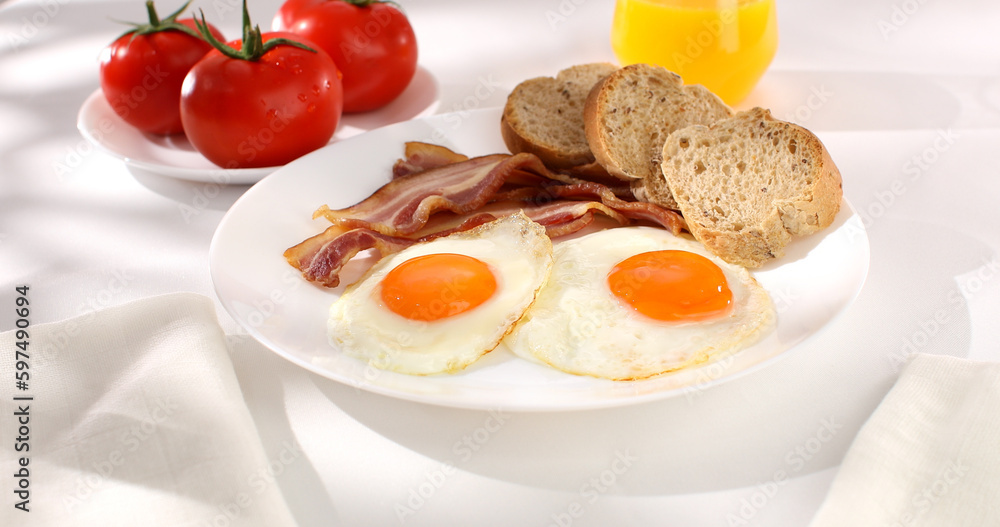 fried eggs with bacon on a plate. breakfast with fresh vegetables and bread on the table. sunny morning. country style. organic farm food fried eggs with bacon on a plate. breakfast with fresh vegetables and bread on the table. sunny morning. country style. organic farm food