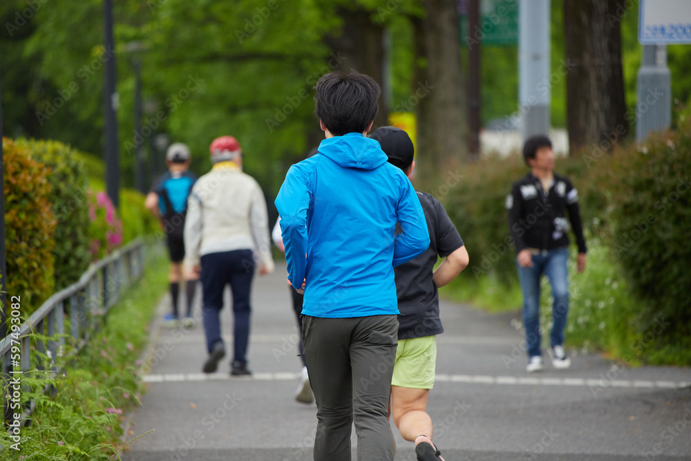 Fototapeta premium 初夏の皇居周辺の道でランニングしている人々の姿