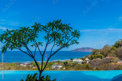 A view past a pool over the resort of Tamarindo towards the bay in Costa Rica in the dry season