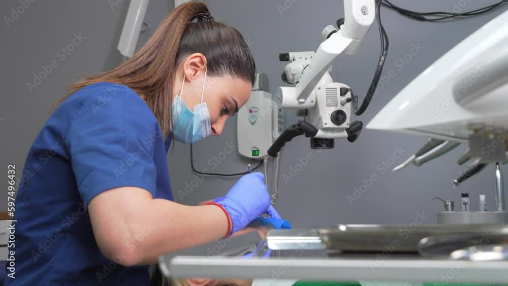 Video „Dentist's hands in gloves with dental punch and cofferdam scarf