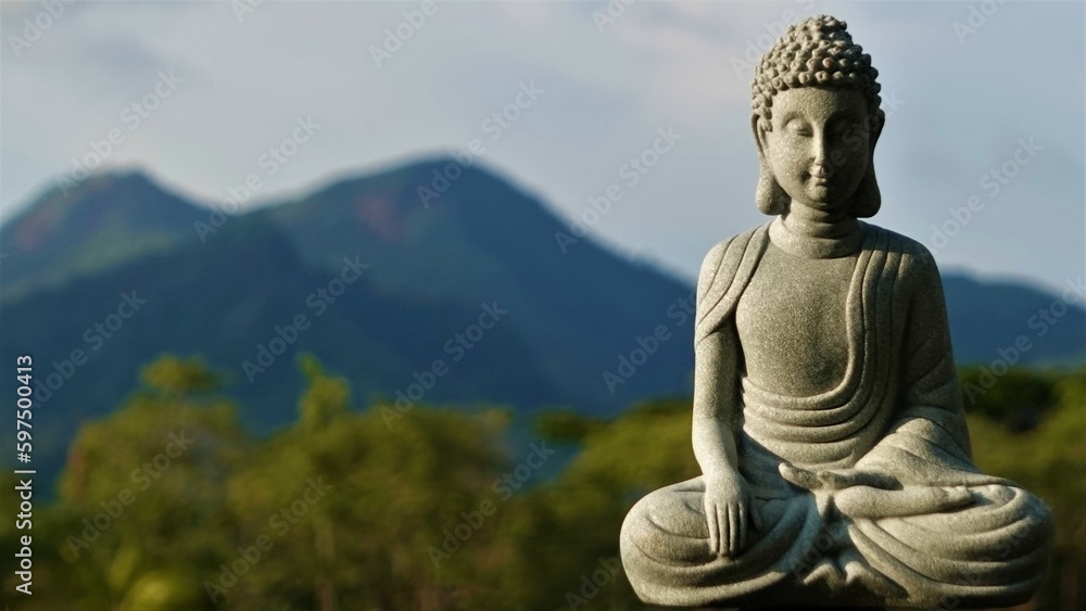 Obraz premium A stone Buddha in the lotus position meditates with his eyes closed – a statue of an Indian god. 