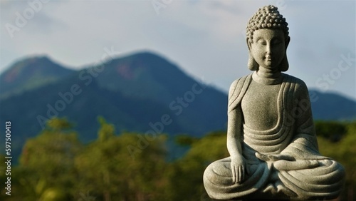 A stone Buddha in the lotus position meditates with his eyes closed – a statue of an Indian god. 
