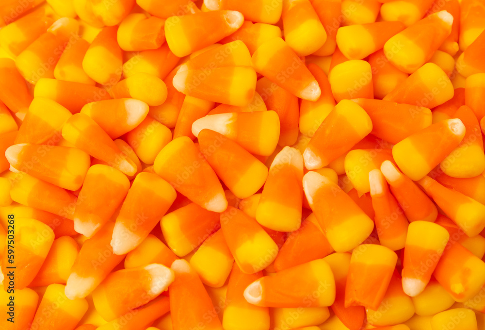 Halloween candy corn on texture background.Classic white, orange and yellow candy corn sweets for Halloween with.copy space.Halloween holiday concept with candy corn and jack o lantern.copy space