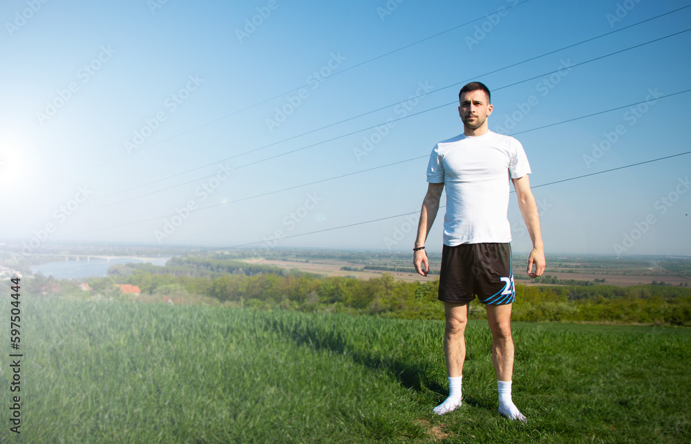 young guy focused on goals, training in nature in socks, merging with nature, beauty landscape