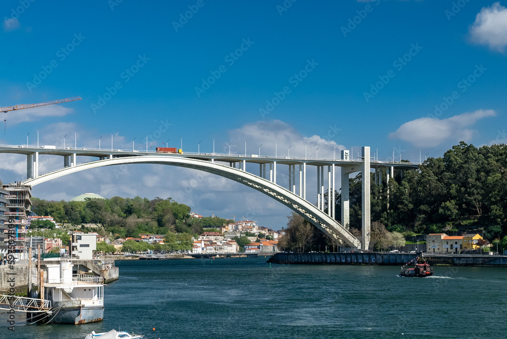 Oporto, Portugal. April 13, 2022: Arrábida bridge and city landscape with blue sky.
