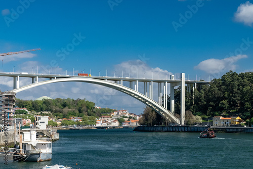 Oporto, Portugal. April 13, 2022: Arrábida bridge and city landscape with blue sky.