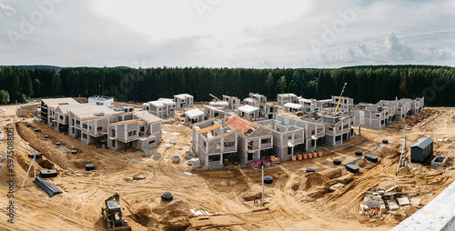 Construction of Cottage, townhouse and line house. Townhouses and suburd two-floor home construction. Suburb houses and modern residential buildings. Roofs of suburban private houses in forest area photo