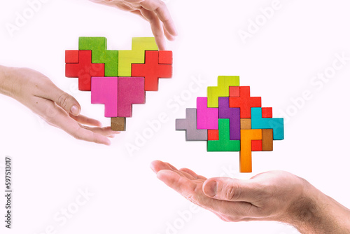 Mans hand holding abstract brain and female hand holding abstract heart. Heart vs Mind, different thinking