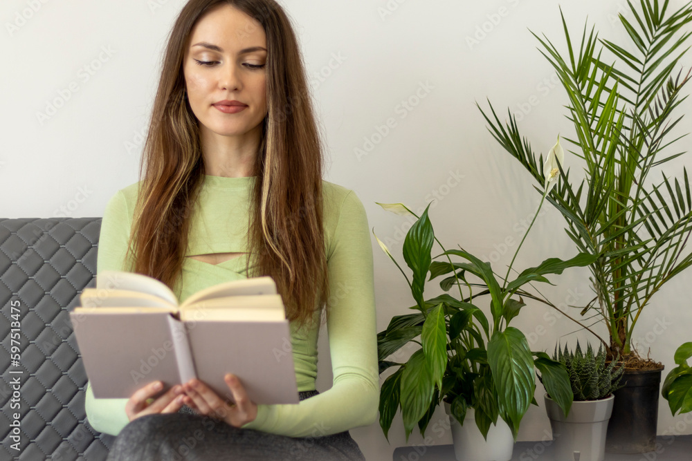 A happy, beautiful young woman with long hair and a book in her hands, reading A happy, beautiful young woman with long hair and a book in her hands, reading
