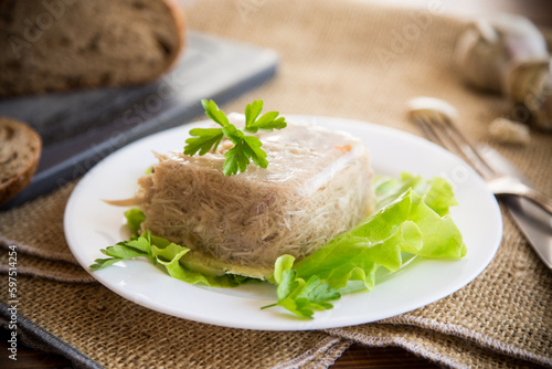 Valokuva Boiled chicken meat aspic in meat gelatin broth in a plate