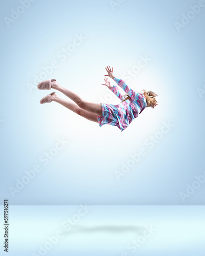 Having nice dreams. Young girl in colorful pajamas, sleeping mask and slippers flying over light blue background. Concept of fantasy, inner world, dreams, surrealism, creativity, psychology