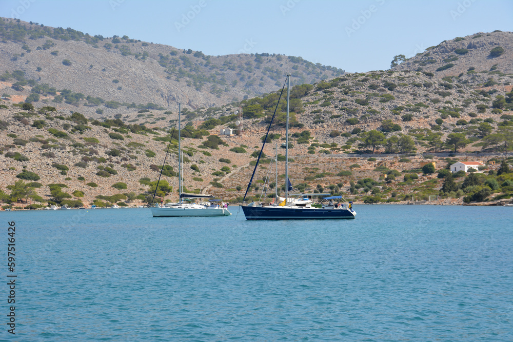 Obraz premium A boat in a bay with a blue sea and mountains on background 