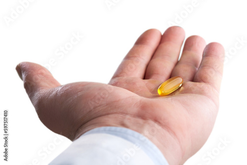 Fish oil pill in hand isolated on white