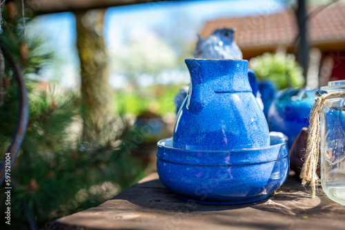 Still life with flowers in the garden and blue dishes on a wooden table in the garden