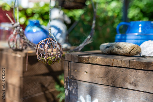 A rusted metal ball with moss as a garden decoration with wooden exterior