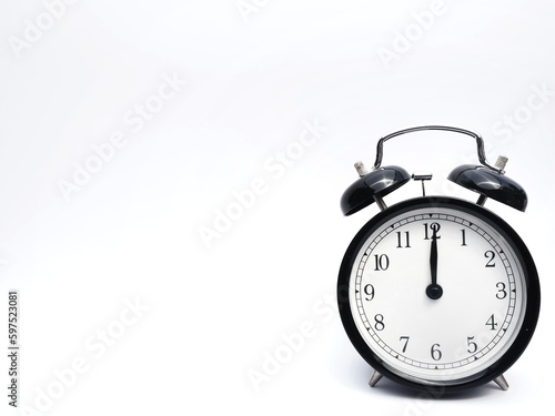 Black retro alarm clock at 12 o clock on a white background with space to add text