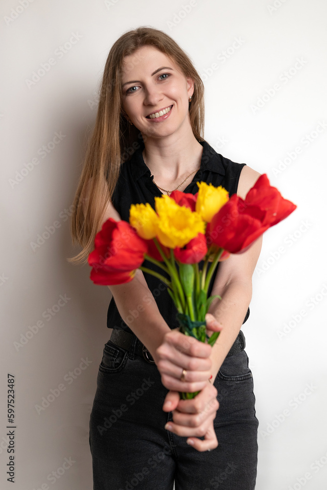 Portrait of young pretty woman, smiling and holding beautiful bouquet of flowers red tulips on white background. Spring, happiness and celebration concept. Portrait of young pretty woman, smiling and holding beautiful bouquet of flowers red tulips on white background. Spring, happiness and celebration concept.
