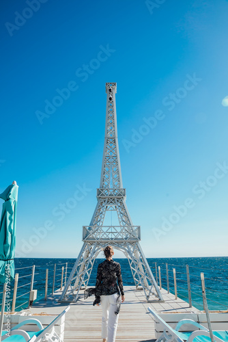 woman near the model of the tower by the sea