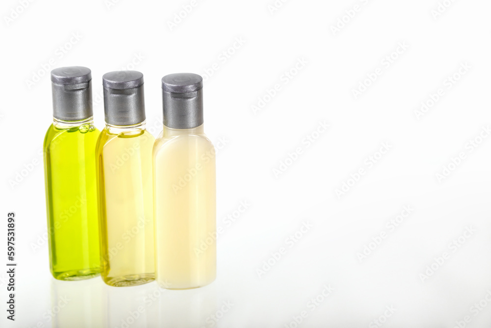 Three small bottles of cosmetics on white background with copy space. Shampoo, shower gel, body lotion. Travel, trips, hotels. Cosmetics mockup, advertising Three small bottles of cosmetics on white background with copy space. Shampoo, shower gel, body lotion. Travel, trips, hotels. Cosmetics mockup, advertising