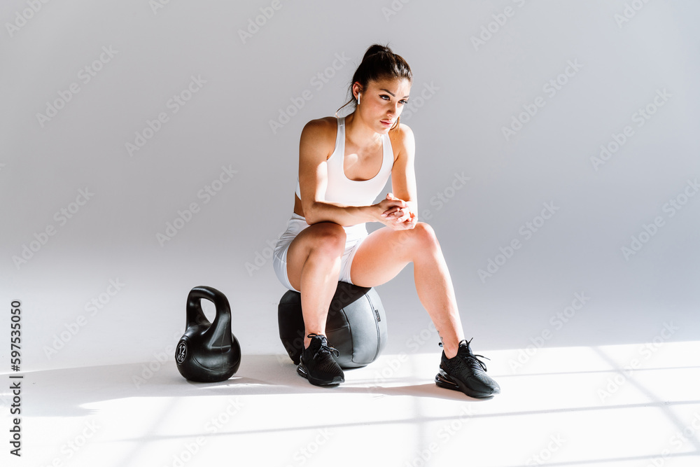 Young female athlete training in a gym using sport equipment. Fit woman working out . Concept about fitness, wellness and sport preparation.