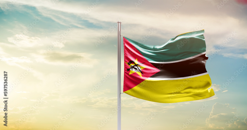 Mozambique national flag waving in beautiful sky. The symbol of the state on wavy silk fabric. - obrazy, fototapety, plakaty 