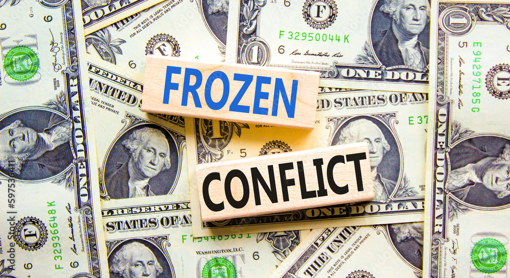 Frozen conflict symbol. Concept words Frozen conflict on beautiful wooden block. Beautiful background from dollar bills. Business and Frozen conflict concept. Copy space.
