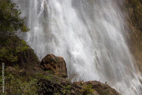 Zona inferior y humeda de la cascada de El Salt de Alcoy con hierbas y roca en primer plano. Espa  a