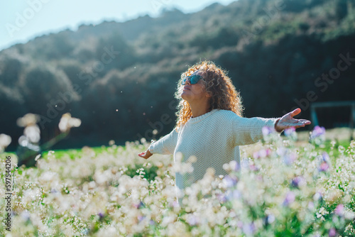 Woman enjoying summer field with white flowers blossom. Healthy lifestyle and freedom people concept. Outdoor overjoyed leisure activity. Lady enjoying summer nature park and travel tour destination photo