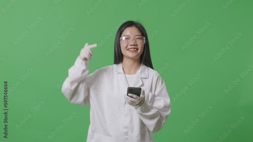 Asian Woman Scientist Smiling And Pointing To Smartphone While Standing On The Green Screen Background In The Laboratory
Asian Woman Scientist Smiling And Pointing To Smartphone While Standing On The Green Screen Background In The Laboratory