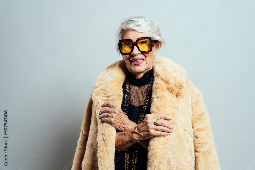 Beautiful and elegant old influencer woman. Cool grandmother posing in studio wearing fashionable clothes. Happy senior lady celebrating and making party. Concept about seniority and lifestyle Beautiful and elegant old influencer woman. Cool grandmother posing in studio wearing fashionable clothes. Happy senior lady celebrating and making party. Concept about seniority and lifestyle