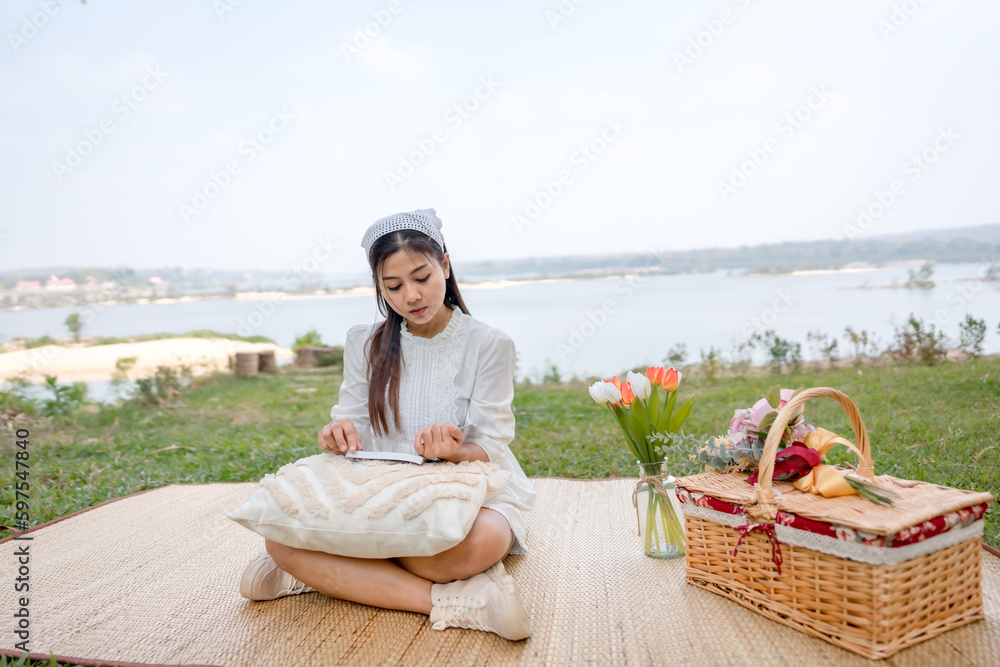 young woman sitting in a public place reading a book on weekends