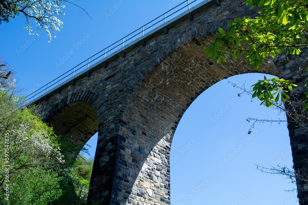 Historic stone railway viaduct on a sunny day against a blue sky