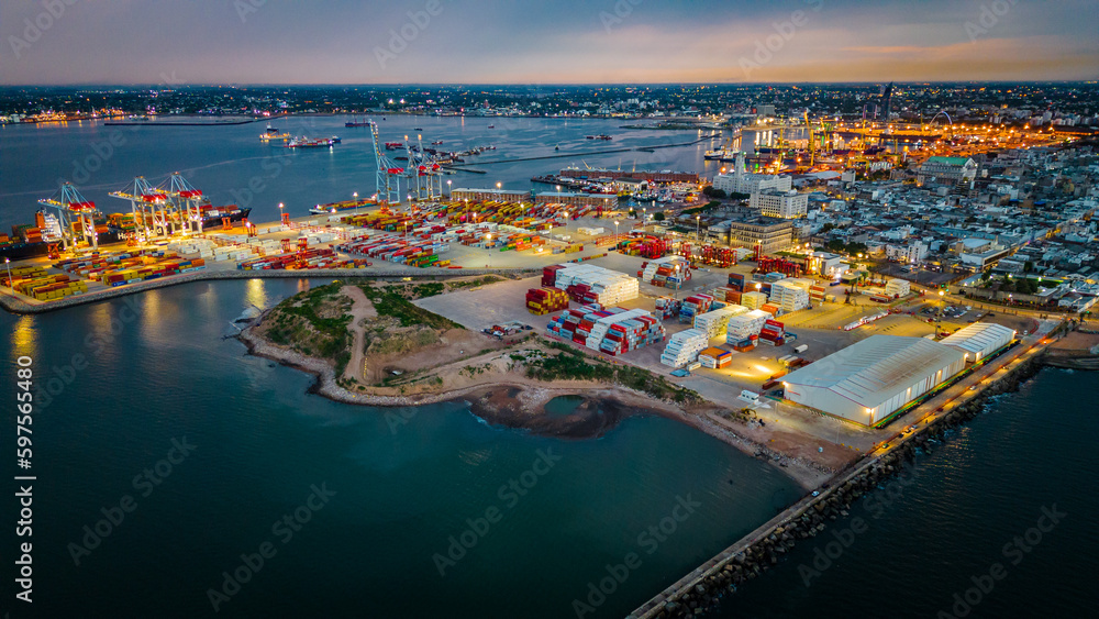 Aerial of Montevideo capital city of Uruguay illuminated at night cargo ship on commercial port harbor