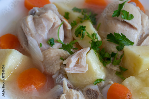 Boiled chicken thigh with potatoes and carrots. Chicken soup .