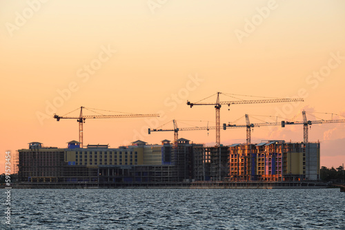 Tower lifting cranes at high residential apartment buildings construction site. Real estate development