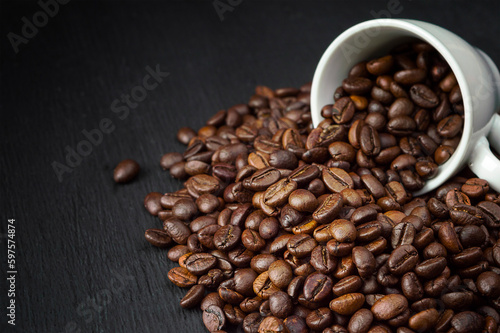 freshly roasted coffee beans.coffee shop.background from scattered coffee beans.Coffee on a dark background. Copyspace