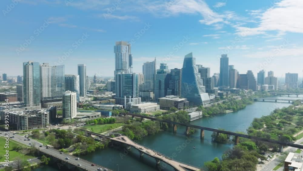 4K aerial of green river parks and Pfluger Pedestrian Bridge at cinematic green Colorado river on beautiful Austin downtown skyline background. Summer vacation in urban city, tourism background USA 4K aerial of green river parks and Pfluger Pedestrian Bridge at cinematic green Colorado river on beautiful Austin downtown skyline background. Summer vacation in urban city, tourism background USA