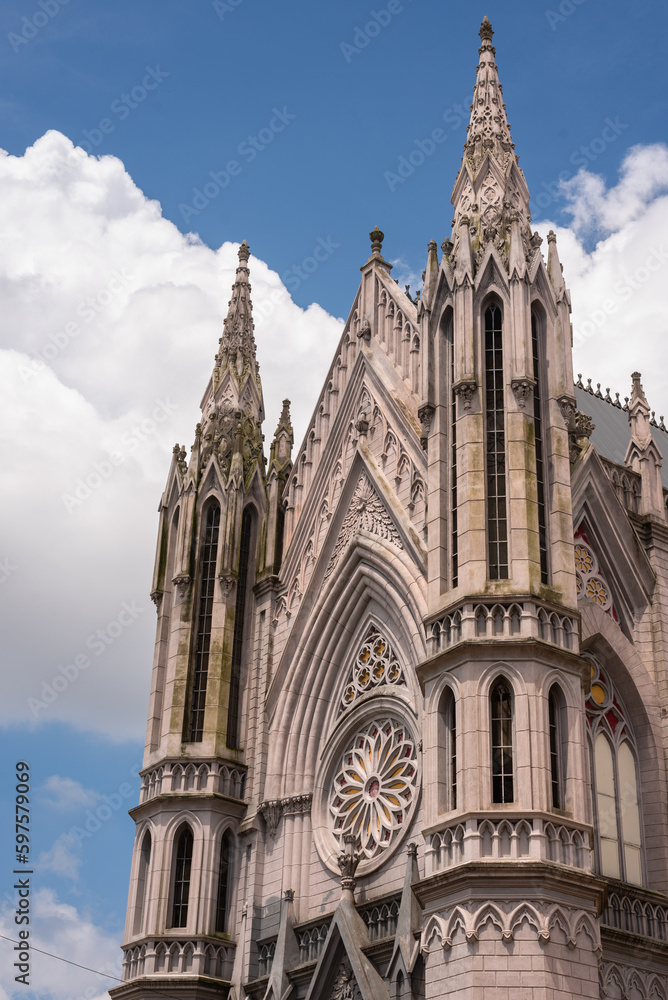 Exterior facade of a neo gothic church with and cloudy sky in background