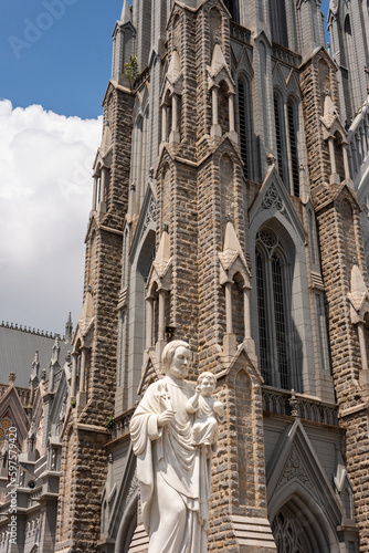 Exterior facade of a neo gothic church with and cloudy sky in background photo