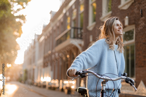 Obraz na plátně Pretty young woman on bicycle in the city street, city transportation