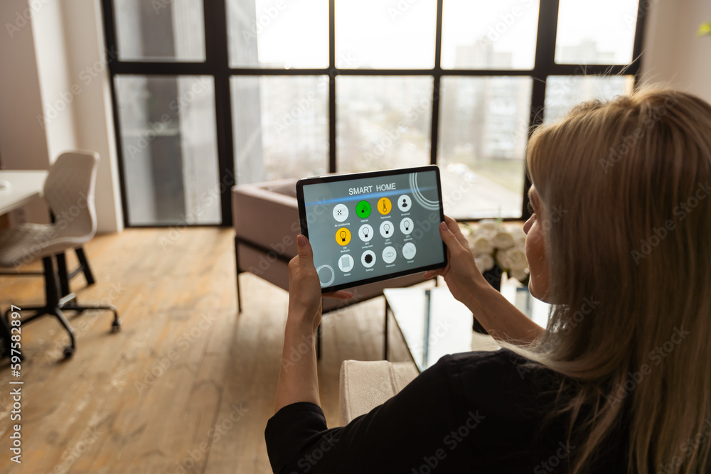 Female hands holding digital tablet with smart home app Female hands holding digital tablet with smart home app