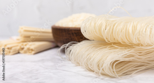 rice noodles. Noodles with rice flour on a white marble background. Funchoza. Dry rice noodles.Close-up.Copy space. Place for text.